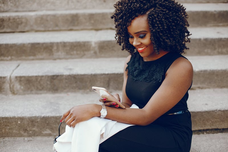 woman on step with her phone with jacket on lap